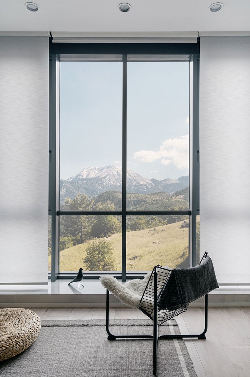 Serene mountain view through modern floor-to-ceiling window in minimalist interior.