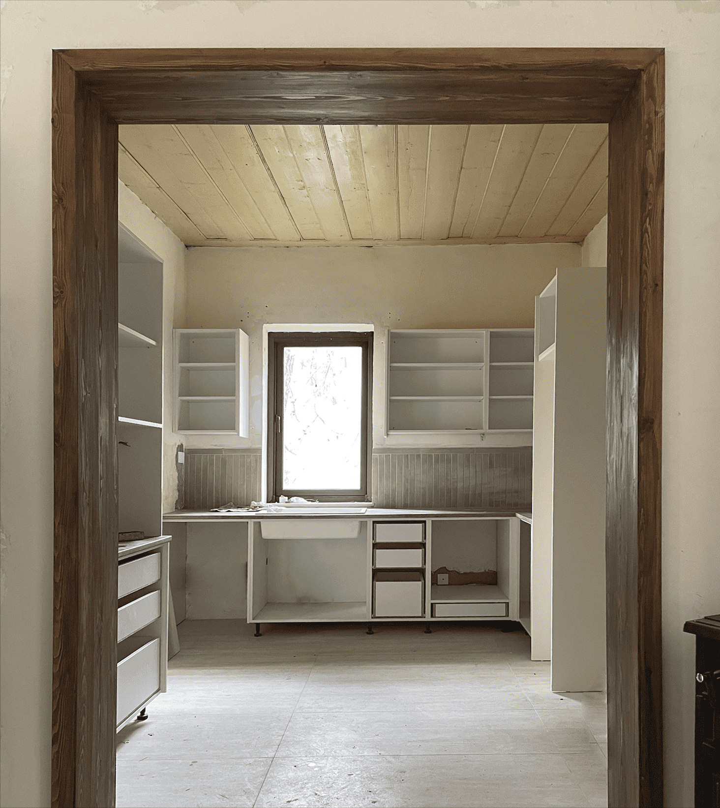 Clean white kitchen cabinets with open shelves and a farmhouse sink, natural light, rustic design, modern interior from Olivehue Interiors.
