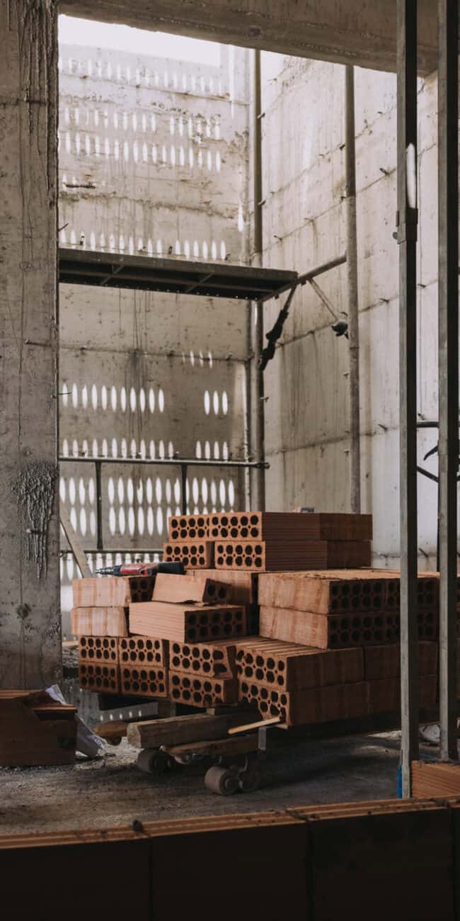 Stacked red bricks for interior construction at Olivehue Interiors construction site.