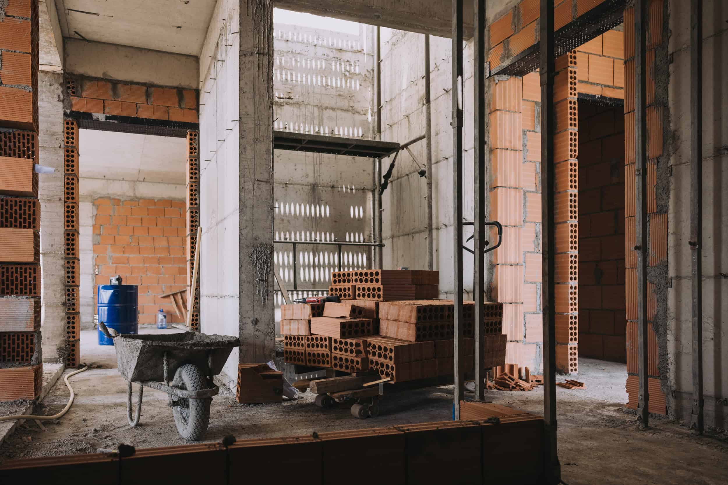 Stacked red bricks for interior construction at Olivehue Interiors construction site.